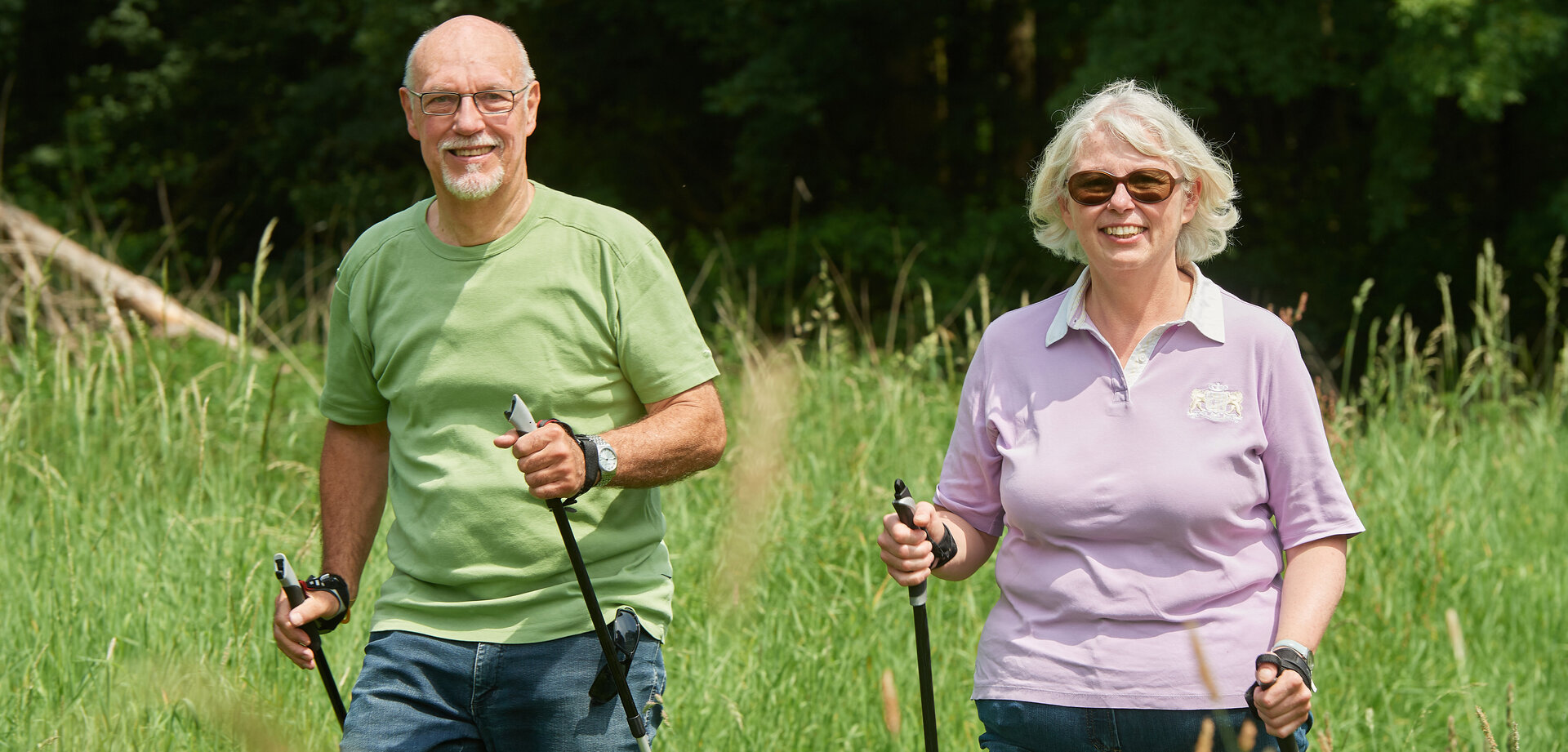 Eine Frau und ein Mann beim Nordic Walking