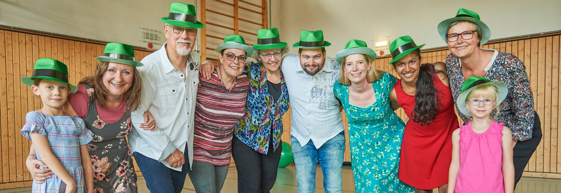 Gruppenbild Menschen mit grünen Hüten